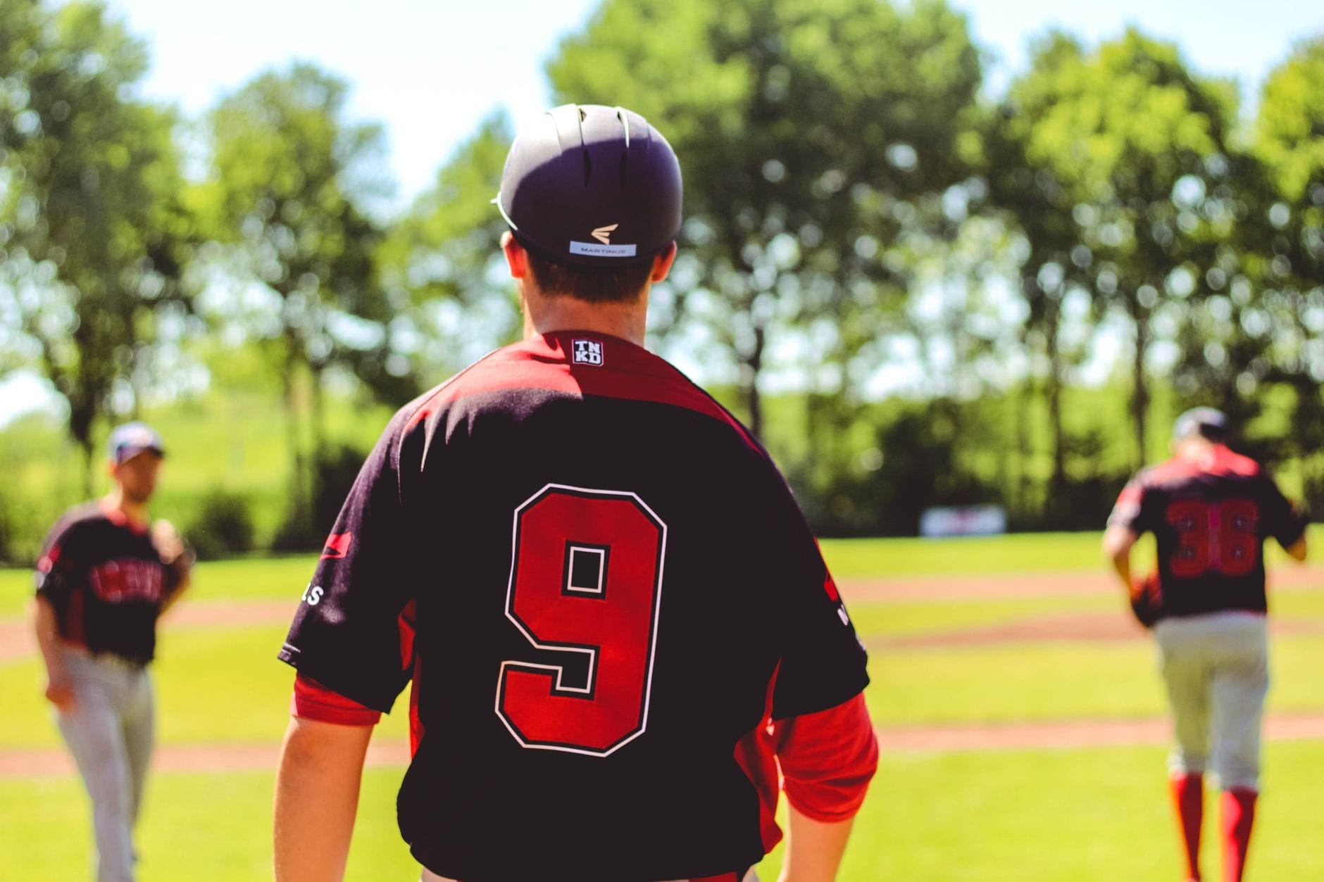 Grupa baseballistów w strojach podczas gry na trawiastym boisku